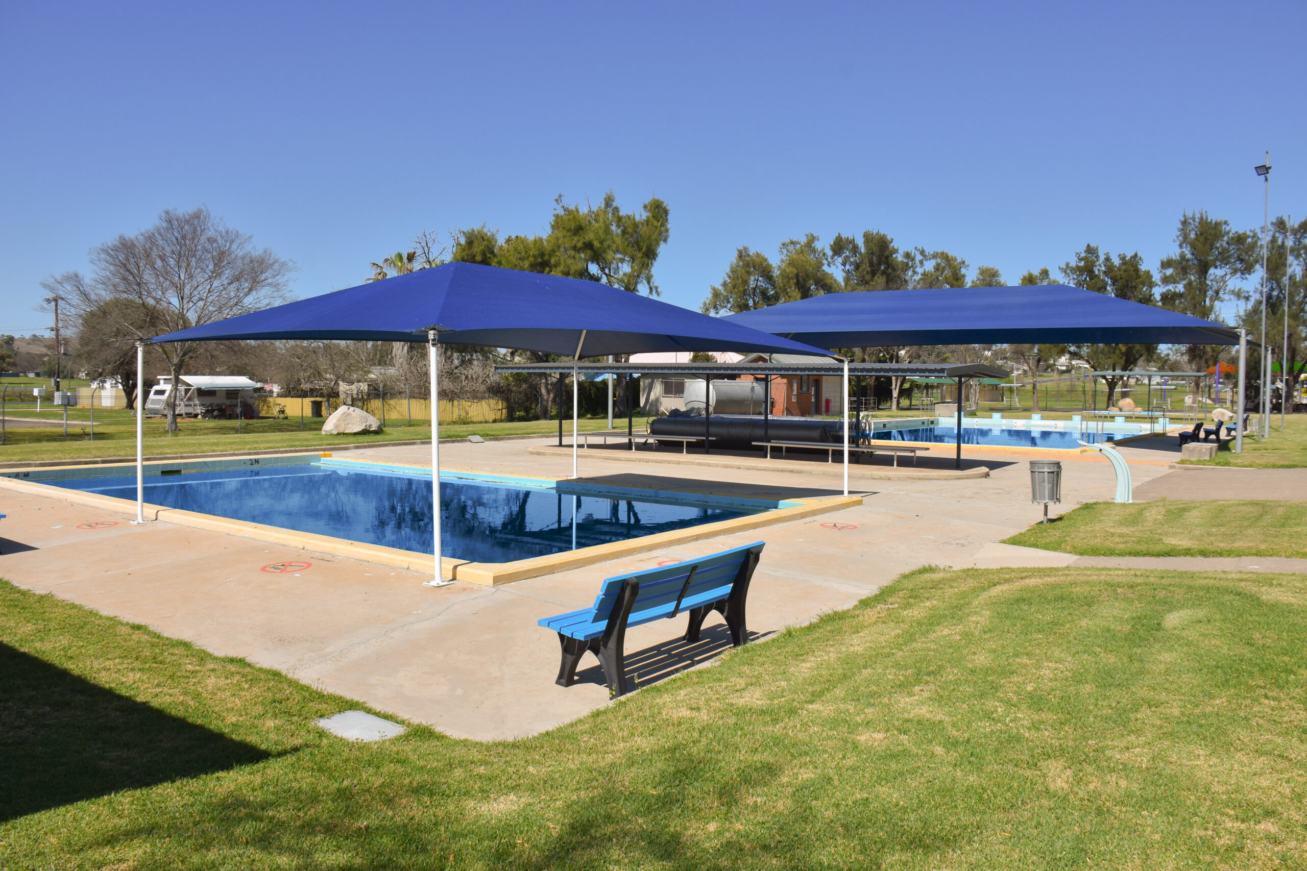 Wide view of Ashford's 2 pools with sunshades over the top